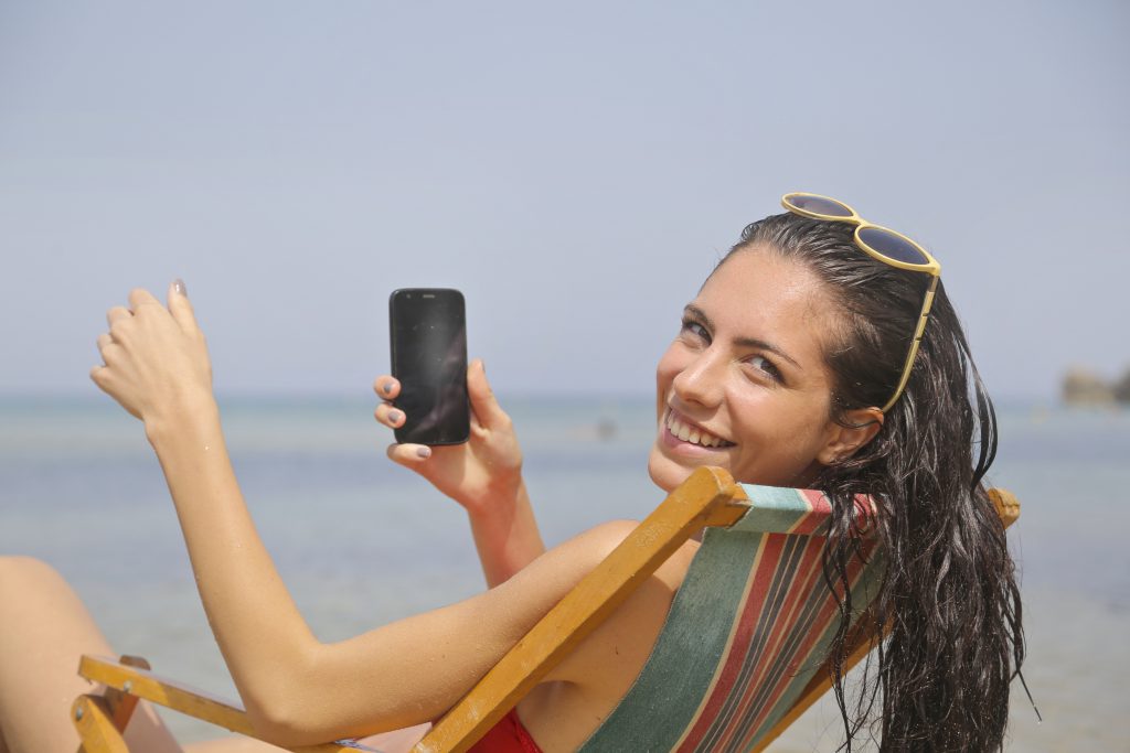 Frau mit Handy am Strand